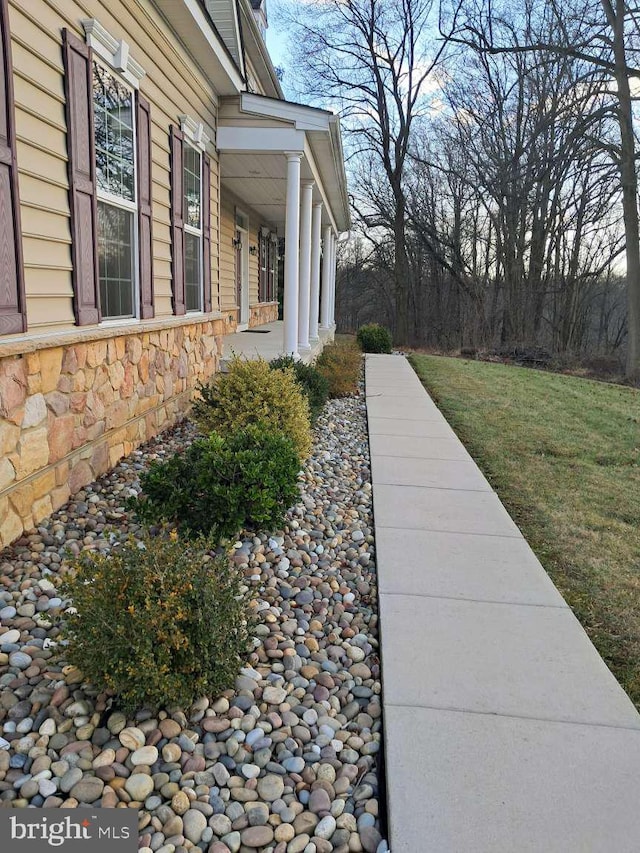 view of home's exterior featuring stone siding and a yard