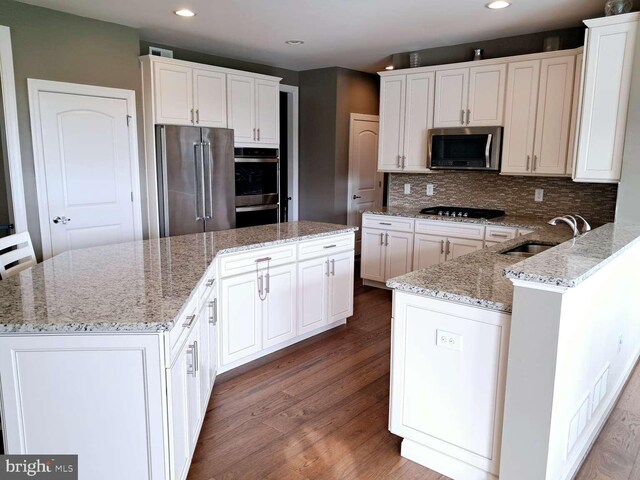 1392 Hickory Hill Rd, Chadds Ford, PA 19317 - kitchen with decorative backsplash, appliances with stainless steel finishes, wood finished floors, a center island, and a sink