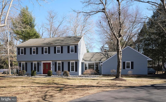 colonial home with a front lawn