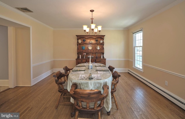 dining area with wood finished floors, visible vents, an inviting chandelier, ornamental molding, and a baseboard heating unit