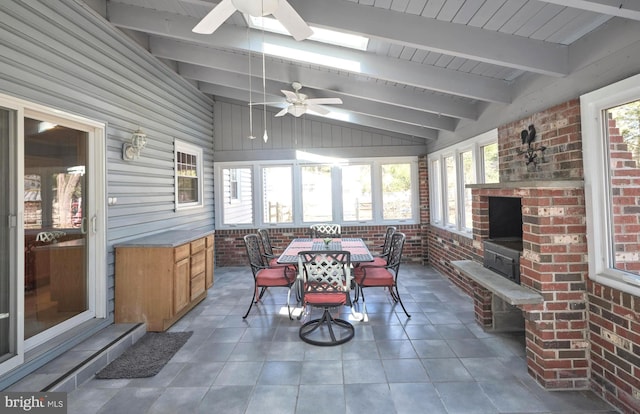 sunroom featuring a healthy amount of sunlight, vaulted ceiling with beams, and a ceiling fan