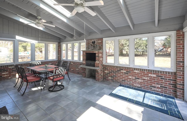 sunroom / solarium with a ceiling fan and vaulted ceiling with beams