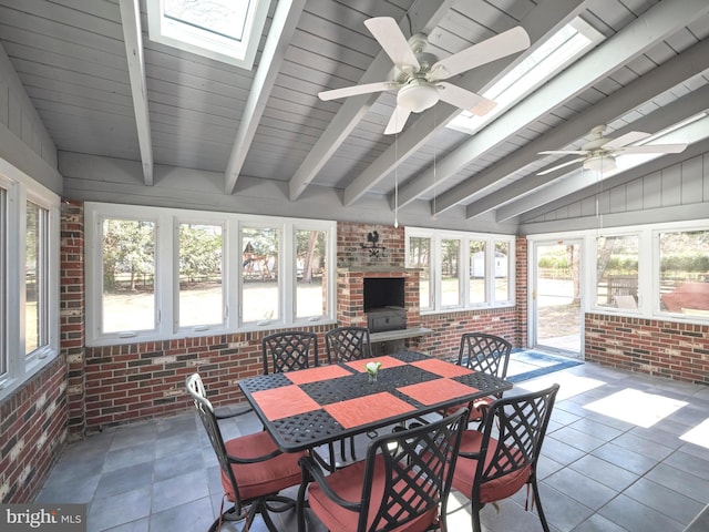 sunroom / solarium featuring vaulted ceiling with skylight and a ceiling fan