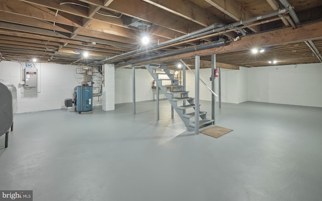 unfinished basement featuring stairs, electric panel, and water heater