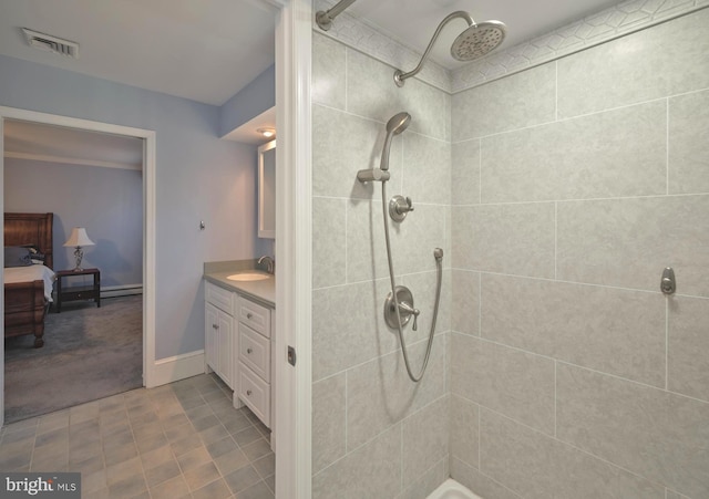 bathroom with a tile shower, visible vents, and vanity