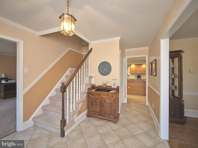 stairway featuring baseboards, crown molding, and tile patterned flooring