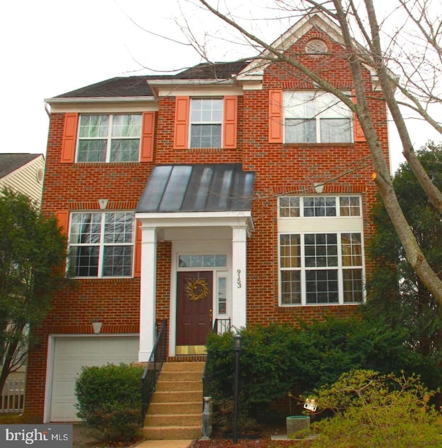 view of front facade featuring brick siding, a garage, metal roof, and a standing seam roof