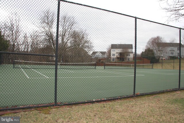 view of tennis court featuring fence