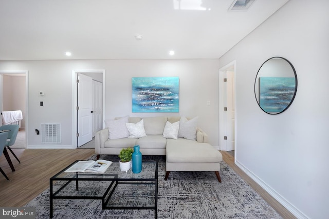 living room featuring recessed lighting, visible vents, baseboards, and wood finished floors