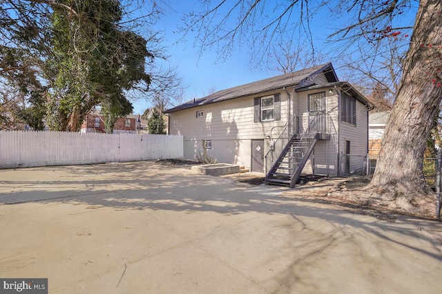 exterior space with a gate, stairs, and fence