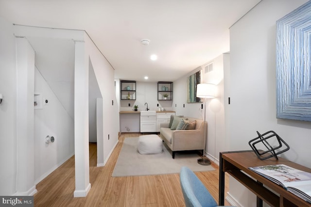 sitting room with light wood finished floors, baseboards, visible vents, and recessed lighting