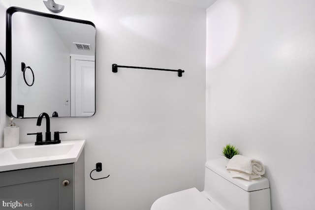 bathroom with visible vents, vanity, and toilet