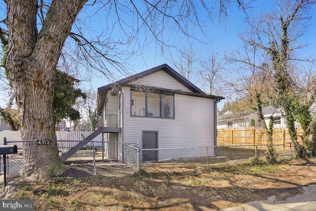 rear view of property featuring a fenced front yard