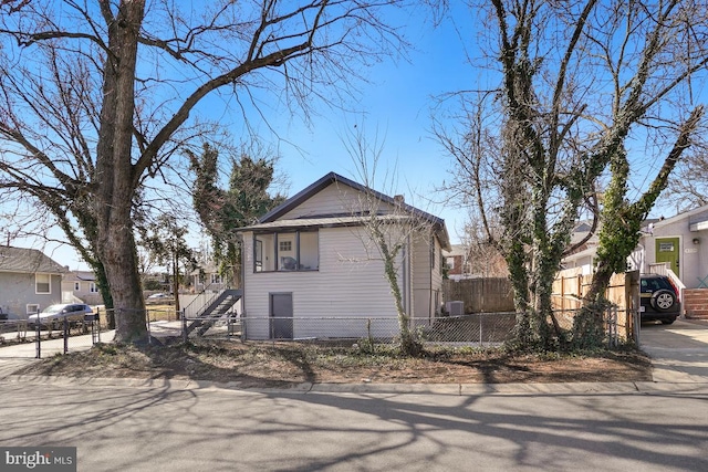 view of side of property with stairway and a fenced front yard