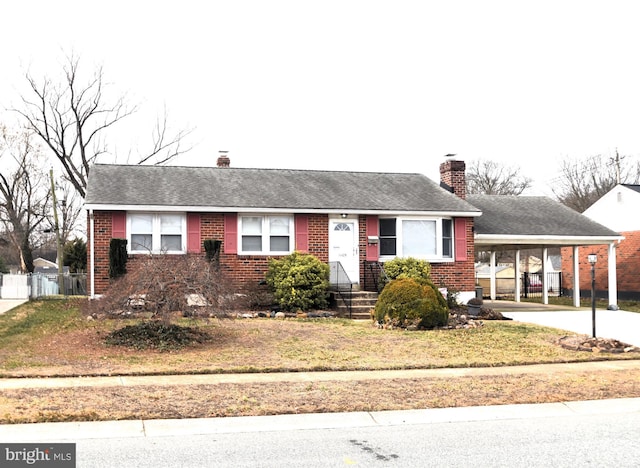 single story home featuring driveway, a shingled roof, a chimney, an attached carport, and brick siding