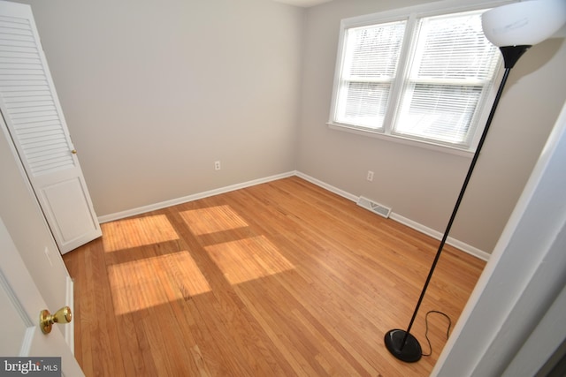 unfurnished bedroom with light wood-type flooring, visible vents, and baseboards