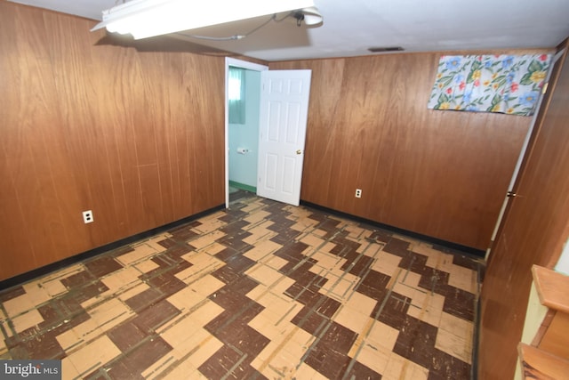 finished basement with wood walls and tile patterned floors