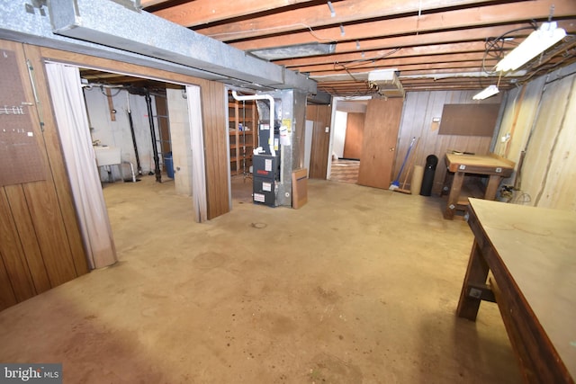 unfinished basement with heating unit and a sink