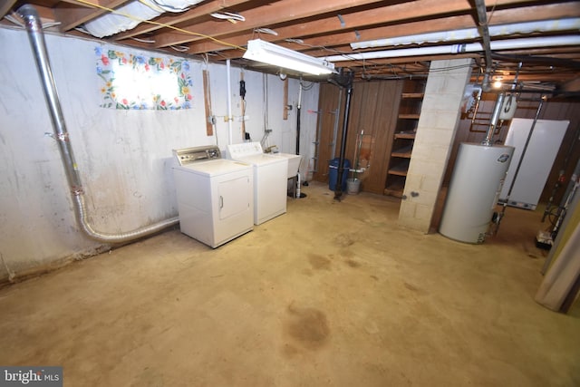 unfinished basement with water heater, a sink, and washing machine and clothes dryer