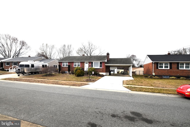 ranch-style house with brick siding, concrete driveway, an attached carport, and a residential view