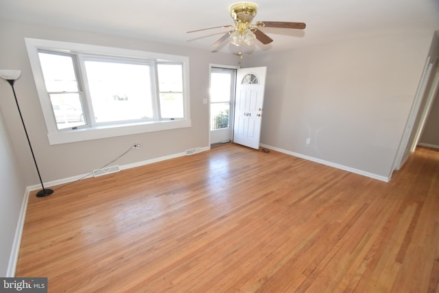 unfurnished room featuring light wood-style floors, visible vents, baseboards, and a ceiling fan