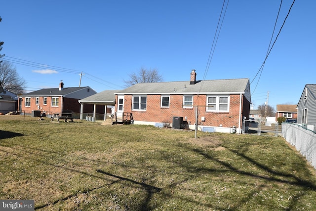 back of house with a chimney, fence, cooling unit, a yard, and brick siding