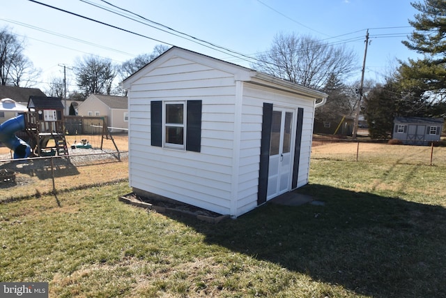 view of shed featuring a playground and fence