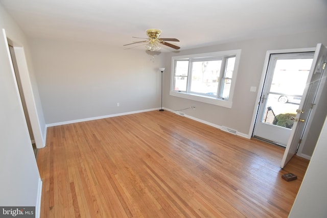 spare room featuring a ceiling fan, light wood-style flooring, visible vents, and baseboards