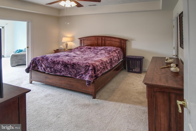 bedroom featuring light carpet, visible vents, and a ceiling fan