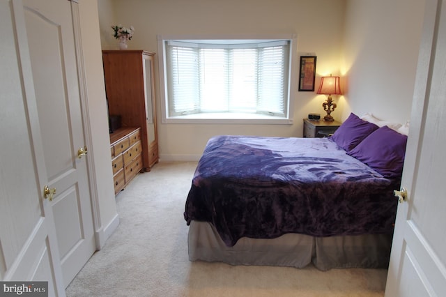 bedroom featuring light colored carpet and baseboards