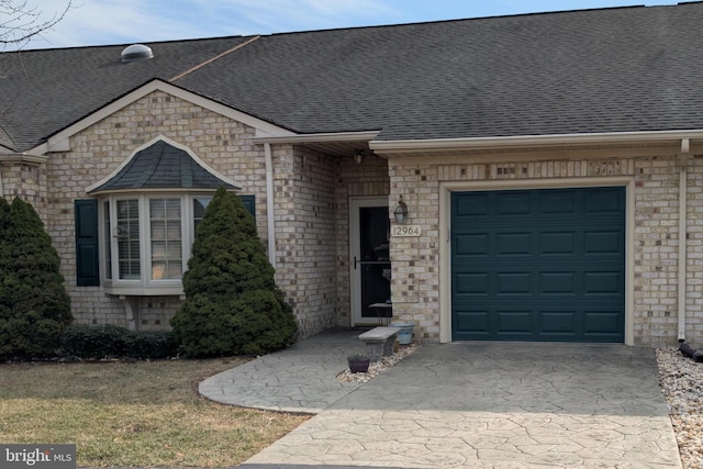 property entrance with a shingled roof, driveway, and an attached garage