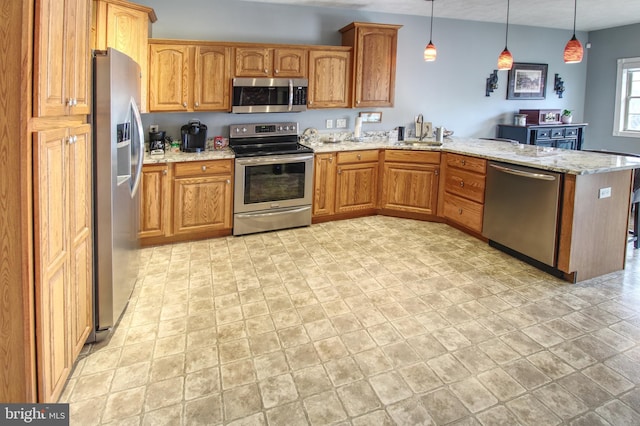 kitchen with appliances with stainless steel finishes, brown cabinetry, a peninsula, and light stone countertops