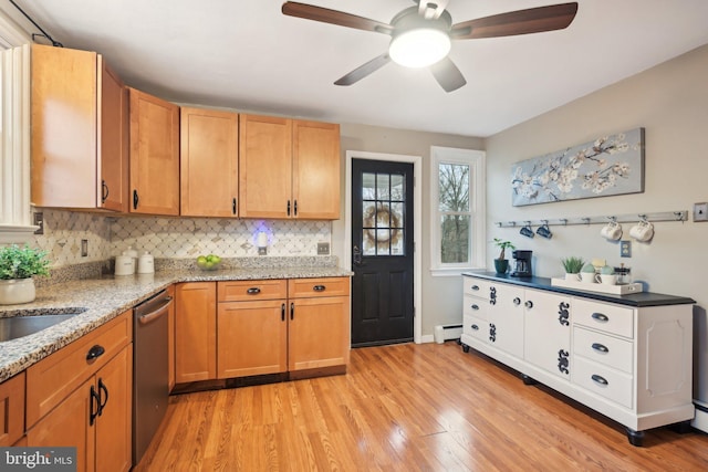 kitchen featuring light stone countertops, light wood-type flooring, stainless steel dishwasher, a baseboard heating unit, and backsplash