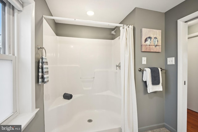 bathroom with a shower with curtain and baseboards