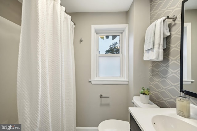 full bathroom featuring toilet, baseboards, and vanity