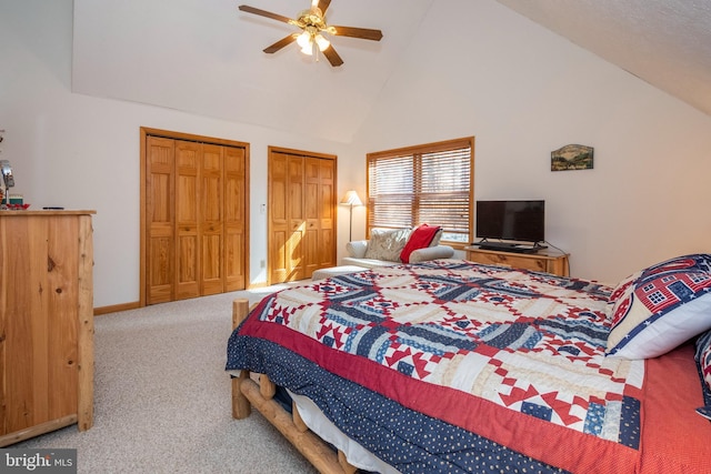 bedroom featuring ceiling fan, high vaulted ceiling, baseboards, multiple closets, and carpet