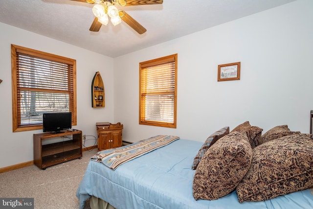 bedroom with a textured ceiling, carpet, a ceiling fan, and baseboards