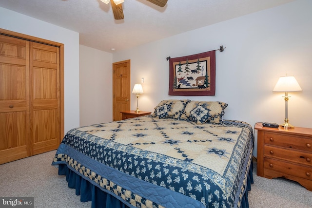 carpeted bedroom with a ceiling fan and a closet