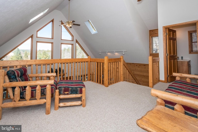 interior space featuring plenty of natural light, a skylight, carpet flooring, and a ceiling fan