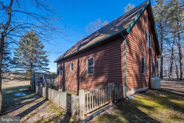 view of side of home with a yard and fence