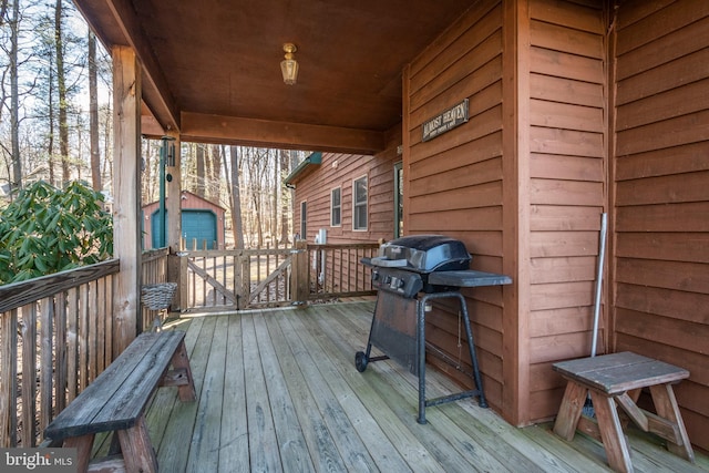 wooden terrace with an outbuilding and grilling area