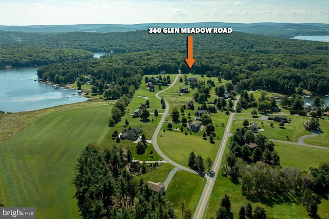 drone / aerial view featuring a water view and a wooded view