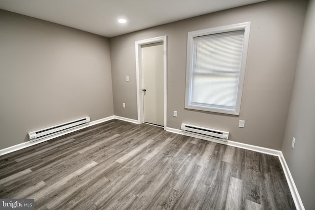 unfurnished room with baseboard heating, recessed lighting, wood finished floors, and baseboards