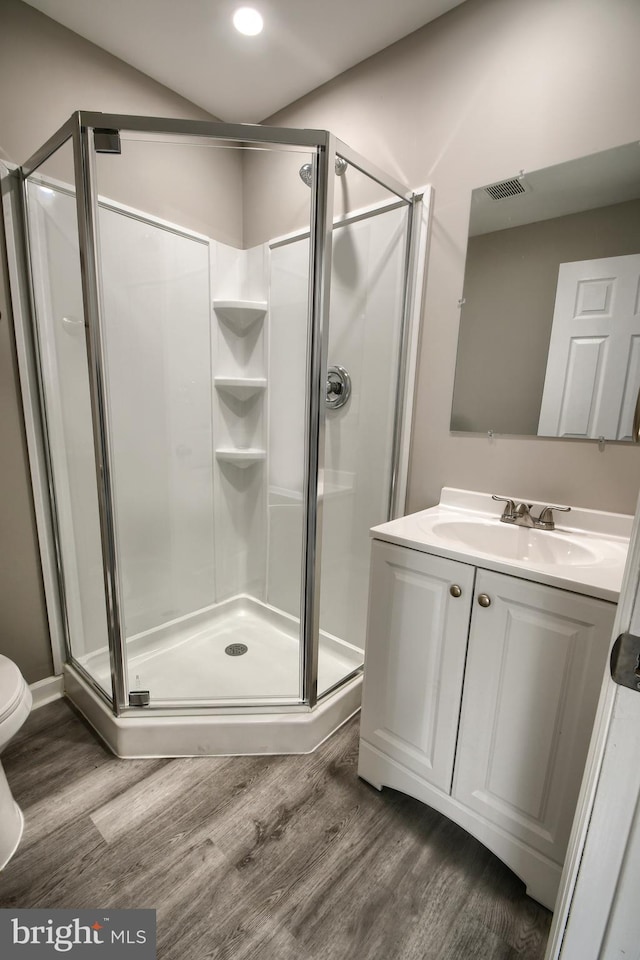 full bath with a stall shower and wood finished floors