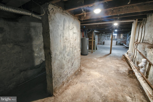 unfinished basement featuring electric water heater