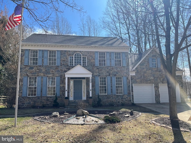 georgian-style home with a garage, stone siding, and driveway