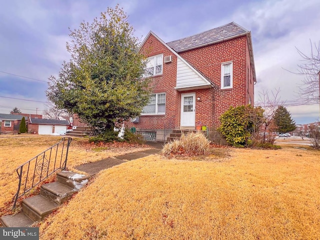 view of front of property with entry steps, brick siding, and a front lawn