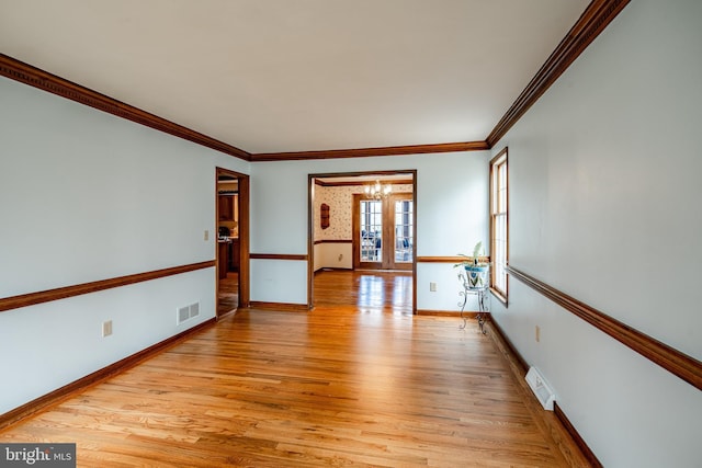 unfurnished room with french doors, light wood finished floors, visible vents, and baseboards