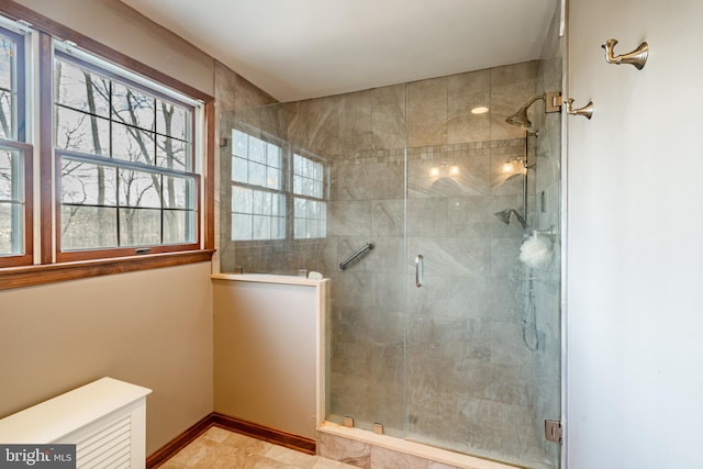 full bathroom featuring a stall shower and baseboards