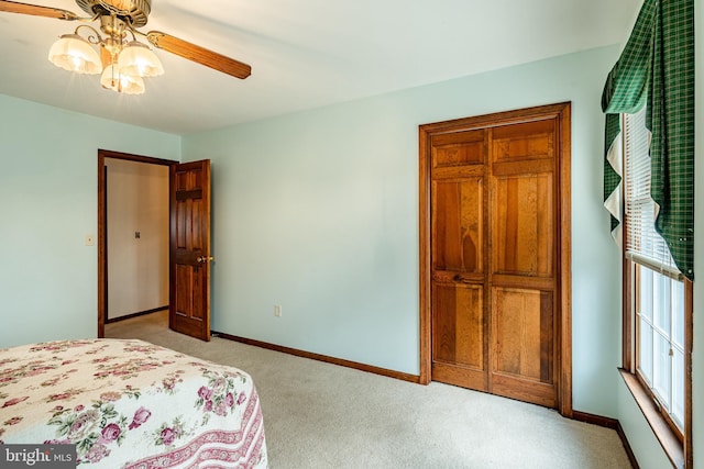 bedroom with light carpet, baseboards, and a ceiling fan